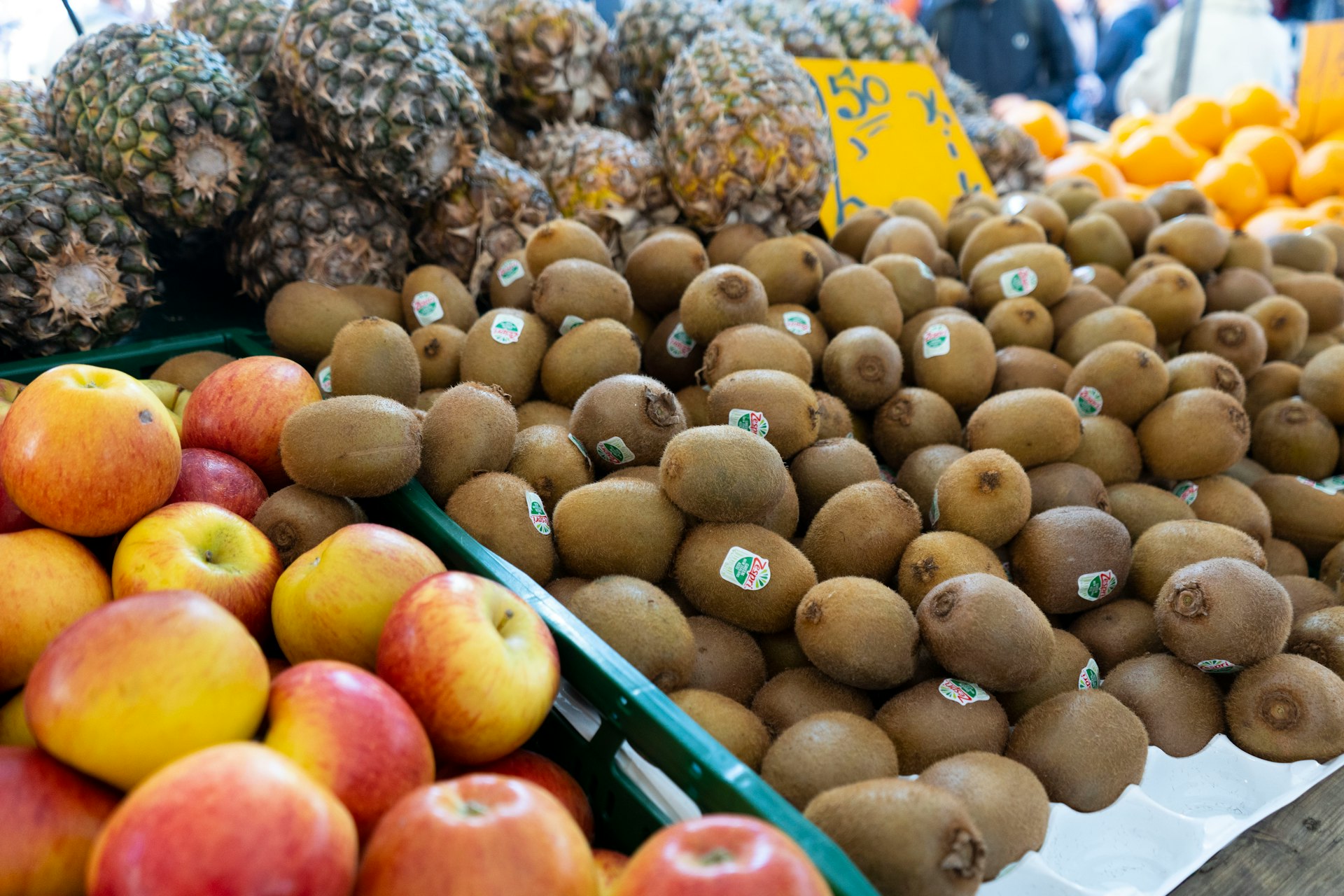 a fruit stand with apples, bananas, and pineapples